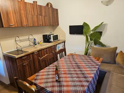 a kitchen with a table and a kitchen with a couch at Емили Фемили Хаус in Koprivshtitsa