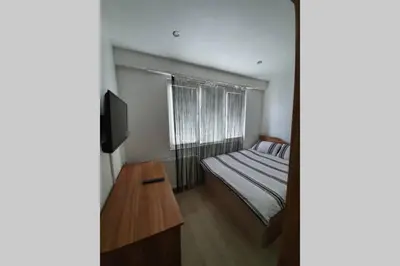 a small bedroom with a bed and a television at Луксозен апартамент с WiFi на 10км от Боровец in Samokov