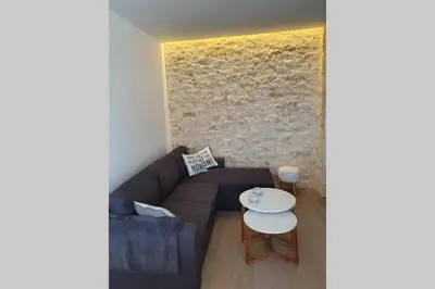 a living room with a couch and a table at Луксозен апартамент с WiFi на 10км от Боровец in Samokov