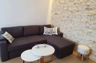 a living room with a couch and two tables at Луксозен апартамент с WiFi на 10км от Боровец in Samokov