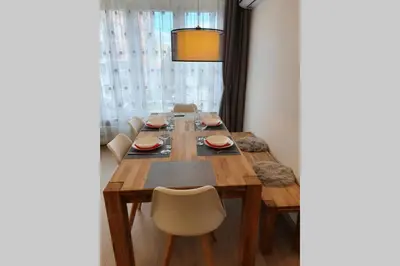 a dining room table with chairs and a wooden table and a tablewered at Луксозен апартамент с WiFi на 10км от Боровец in Samokov
