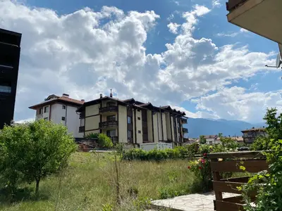 a group of buildings in a field with clouds in the sky at Temerso Studio-Apartment in Bansko
