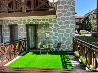 a patio with a table and chairs on a deck at Temerso Studio-Apartment in Bansko