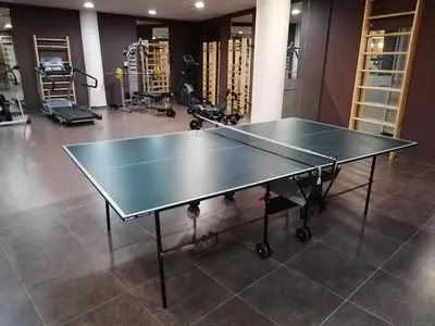 a ping pong table in a gym with exercise bikes at Aspen Golf - private apartments in Razlog