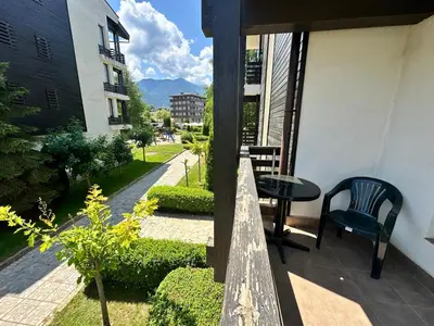 a balcony of a building with a table and chairs at Aspen Golf - private apartments in Razlog
