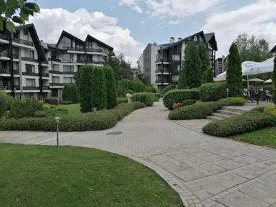 a walkway in a park next to some buildings at Aspen Golf - private apartments in Razlog