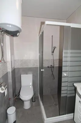 a bathroom with a shower and a toilet in it at Bendida Apartments in Velingrad