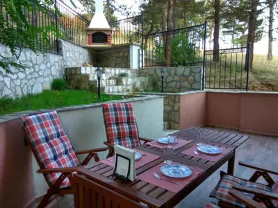a table and chairs with a laptop on a patio at Bendida Apartments in Velingrad