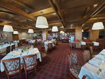 a dining room with tables and chairs and lights at Airy Studio Pirin Golf Aparthotel SPA H2A92 in Razlog