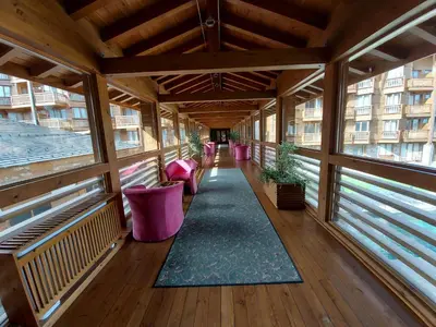 an empty balcony with pink chairs and a rug at Airy Studio Pirin Golf Aparthotel SPA H2A92 in Razlog