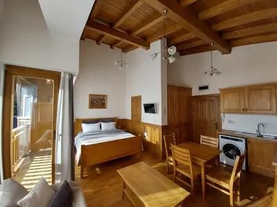 a bedroom with a bed and a table and a kitchen at Airy Studio Pirin Golf Aparthotel SPA H2A92 in Razlog