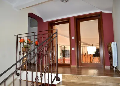 a hallway with a staircase with a vase of flowers at Къщи за гости 