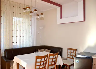 a dining room with a white table and chairs at Къщи за гости 