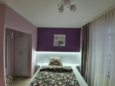 a bedroom with a bed and a purple wall at GUEST SUITE Narodno horo in Sofia