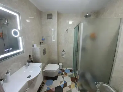 a bathroom with a toilet and a sink and a shower at GUEST SUITE Narodno horo in Sofia