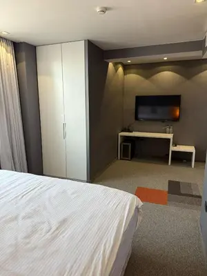 a bedroom with a white bed and a tv at Boutique Hotel Kanyon in Sofia