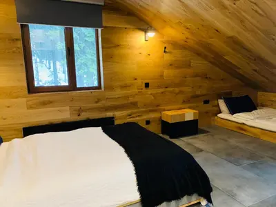 a bedroom with a bed and a window in a log cabin at Golden Box Pamporovo in Pamporovo