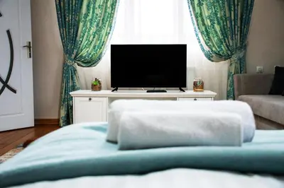 a living room with a bed and a tv at Infinity Boutique Apartments in Bansko
