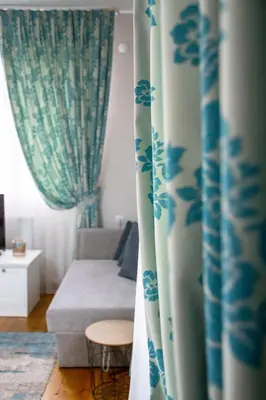 a living room with blue and white curtains and a couch at Infinity Boutique Apartments in Bansko