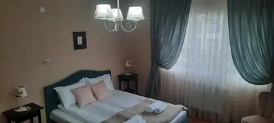 a bedroom with a bed with pink pillows and a window at Infinity Boutique Apartments in Bansko
