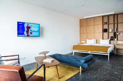 a hotel room with a bed and a blue couch at Hotel Kitchen59 in Sofia