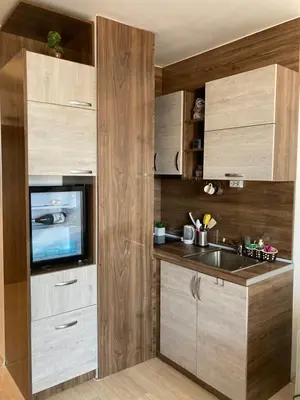 a kitchen with wooden cabinets and a sink at Mirabell Studio Bansko - Amazing view & fireplace in Bansko