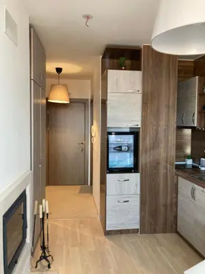 a living room with a television and a kitchen at Mirabell Studio Bansko - Amazing view & fireplace in Bansko