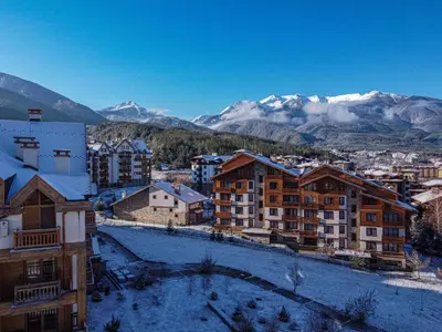 a city with snow covered buildings and mountains at Mirabell Studio Bansko - Amazing view & fireplace in Bansko