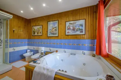 a bathroom with a tub and a toilet at Villa Anna Luxury Lake Residence in Shtarkelovo Gnezdo