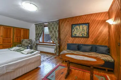 a bedroom with a bed and a table and a couch at Villa Anna Luxury Lake Residence in Shtarkelovo Gnezdo