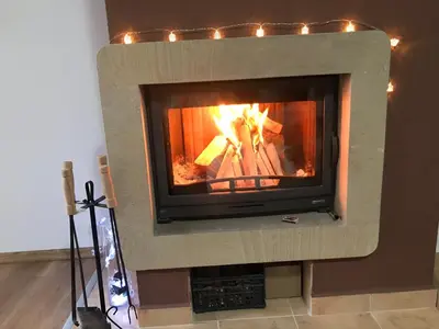 a stone fireplace with a fire in it at Marina Apartment in Bansko
