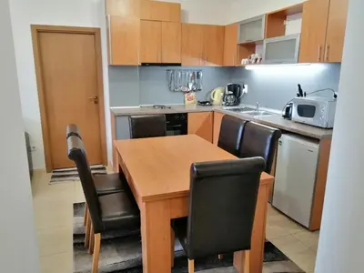 a small kitchen with a wooden table and chairs at GRAND MONASTERYl Apartment ``Star Paradise`` in Pamporovo
