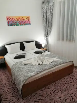 a bedroom with a bed with a robe on it at GRAND MONASTERYl Apartment ``Star Paradise`` in Pamporovo