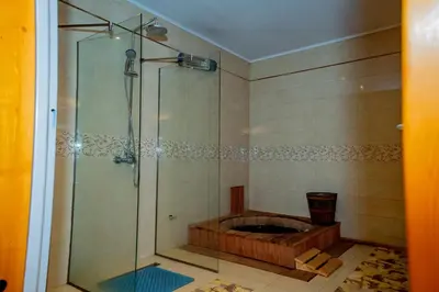 a shower with a wooden tub in a bathroom at Luxury houses in Dobrinishte in Dobrinishte