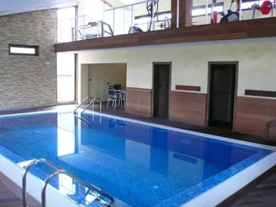 a large swimming pool with blue water in a building at Cozy Fortuna Apartments 46 in Bansko