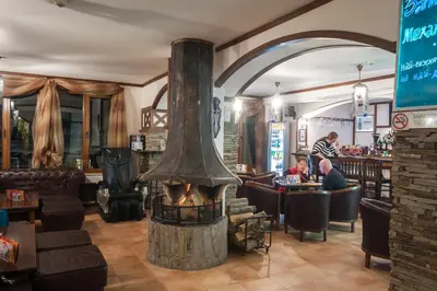 a restaurant with a fireplace in the middle of a room at Studio - Apartments Castle Complex 2 in Pamporovo