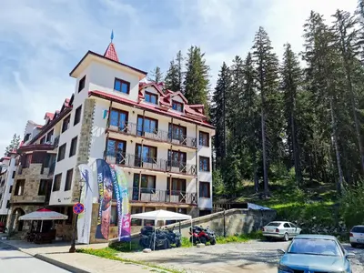 a large building with cars parked in front of it at Studio - Apartments Castle Complex 2 in Pamporovo