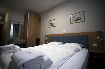 a bedroom with a large bed with towels on it at AquaSun Family Hotel in Sandanski