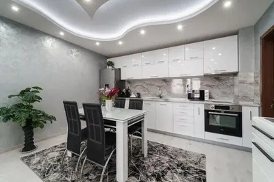 a kitchen with white cabinets and a table and chairs at City Apartments - a brand new luxury & comfy 2 in Asenovgrad