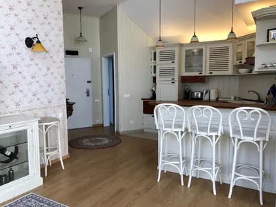 a kitchen with white chairs and a counter top at LUXURY PENTHOUSE WITH A LAVISH SPA and 2 en-suite bedrooms in Bansko