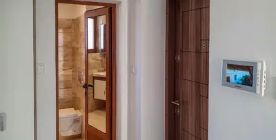 a bathroom with a toilet and a television on a door at ALBISTO Dragalevtsi Luxury Apartments in Sofia