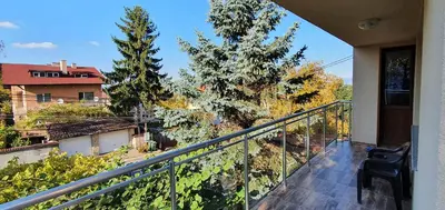 a balcony with a view of trees and a building at ALBISTO Dragalevtsi Luxury Apartments in Sofia