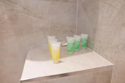 a row of glasses sitting on a shelf in a shower at Shushi's Central Studio Apartment in Plovdiv