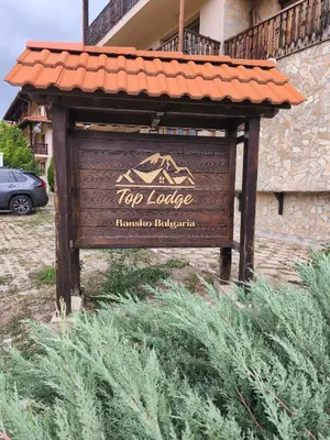a sign for a yoga lodge in front of a building at Apartament 4 seasons - Top Lodge in Bansko