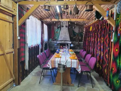 a dining room with a table and purple chairs at GUEST HOUSE TONI СТАИ за ГОСТИ ТОНИ in Ribarica