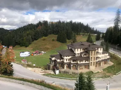 a large house on top of a hill with trees at Апартамент Пампорово Палас - Pamporovo Palace in Pamporovo