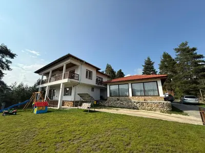 a house with a large yard in front of it at Вила Слънчев Бряг in Dospat