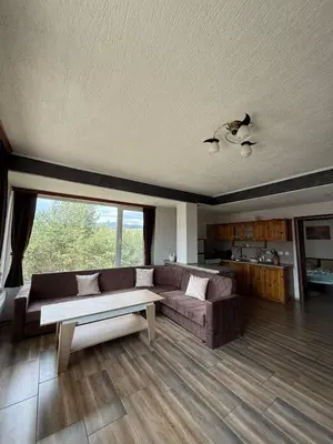 a living room with a couch and a table at Вила Слънчев Бряг in Dospat
