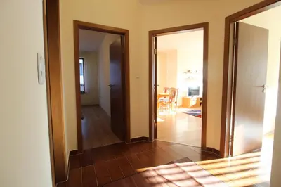 a hallway with two doors and a dining room at 2 bedroom apartment near Gondola in Bansko