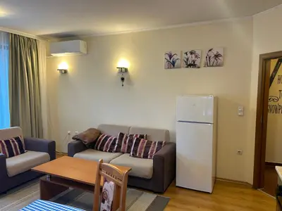 a living room with a couch and a refrigerator at 2 bedroom apartment near Gondola in Bansko